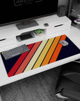 Artistic 36x16 inches mouse pad with bold diagonal stripes in warm orange, red, and yellow, set against a navy background for a classic retro look.