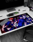 Isagi Yoichi front and center on Blue Lock desk pad 40x20 inches, teammates crowding behind in hype.