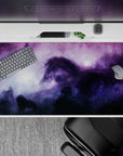Calm magical purple-to-inky-blue galaxy desk pad with misty light blooms, 40x20 inches.