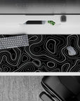 36x16 inches desk pad with black and white topographic design, blending bold lines and dotted patterns for a sleek, graphic style.