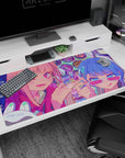 Winking pink-haired anime girl and blue-haired friend in sunglasses on desk pad 40x20 inches.