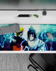 Naruto and Sasuke back-to-back under a moonlit sky on a 36x16 inch anime desk pad, capturing tension and history.