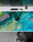 Serene 40x20 desk pad featuring turquoise and deep blue tones with golden flecks, perfect for bringing the calm energy of the sea to your desk