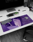 Sasuke Uchiha with Mangekyō Sharingan from Naruto on a 36x16 inch anime mouse pad, purple hues creating an intense scene.