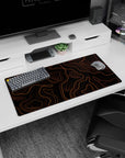 Modern 32x16 inches mouse pad featuring orange topographic contours, blending bold orange lines with a sleek black backdrop for an eye-catching design.