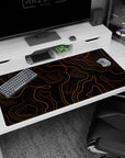 Large 40x20 inches desk pad featuring orange topographic contours, with dynamic orange lines on a black backdrop for a bold and sophisticated design.