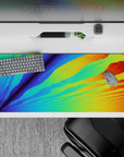 Radiant 36x16 desk pad featuring a digital sunrise effect with vibrant blues, greens, oranges, and yellows for a bold look