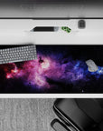 Purple haze and electric blue on midnight black desk pad 36x16 inches, calming dreamy space mood.