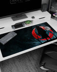 Blood-red moon and iconic Itachi silhouette on 40x20 desk pad create an atmospheric workspace for Naruto enthusiasts