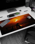 Large 40x20 inches desk pad with a lone figure kneeling beneath a fiery sunset, surrounded by dark silhouettes, ideal for adding depth and solitude to your workspace.