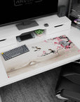 Artistic 36x16 inches desk pad featuring plum blossom and bird design, blending delicate pink flowers and a serene bridge for mindfulness and calm.