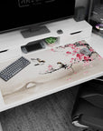 Large 40x20 inches desk pad featuring plum blossoms and birds, blending soft pink blooms, a tranquil bridge, and mist for a serene workspace vibe.