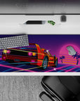 Striking 36x16 desk pad highlights speeding sports car under glowing sunset with vibrant neon details