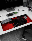 Artistic 36x16 inches desk pad featuring Guts in his Berserker Armor with a fiery red background and menacing silhouette, perfect for bringing intense energy to your workspace.