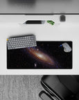 Dreamy black space mouse pad 28x12 inches with wispy blues, violet haze, and amber sparks.