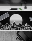 40x20 inches desk pad with minimalist black-and-white wireframe mountains beneath a glowing, striped sun in vaporwave style.