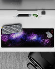 Large 32x12 inch mouse pad featuring deep space design with violet nebula, blue stardust, and starry night hues.