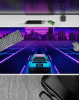 40x20 inches desk pad with a sleek neon grid and a futuristic car, cruising toward a vibrant city lit in pink and purple hues.