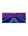 Mouse pad featuring Neon City Cruise, 28x12 inches, with a neon-lit car cruising toward a vibrant city grid in pinks and purples.