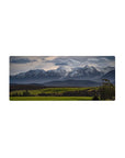 Mouse pad featuring snow-capped peaks, 28x12 inches, with lush greenery for a serene and dynamic nature-inspired design.