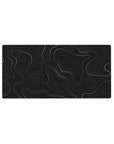 Mouse pad featuring golden topographic lines on a deep black background, 32x16 inches, perfect for adding modern elegance and functionality to your desk.