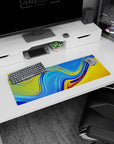 Artistic 32x12 inches mouse pad showcasing vibrant sunset liquid waves in vivid blue and golden yellow, perfect for brightening your desk setup.