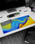 Artistic 36x16 inches desk pad showcasing swirling sunset liquid waves in bright colors, perfect for those who love dynamic, fluid artwork.