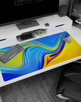 Large 40x20 inches desk pad featuring vivid blue and golden yellow liquid wave patterns, perfect for adding bright, dynamic energy to your workspace.