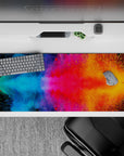 36x16 inches desk pad with dynamic cosmic color bursts, blending vibrant hues of blue, pink, and orange for an energetic workspace.