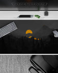 40x20 inches mouse pad with moody mountain landscape, featuring silhouetted pines, deep grays, and a glowing orange sun for a bold, mysterious vibe.