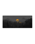 Mouse pad featuring moody mountain landscape, 28x12 inches, with silhouetted pines, deep grays, and a glowing orange sun for a striking aesthetic.