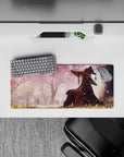 Megumin from Konosuba anime mouse pad, 28x12 inches, under sakura trees with pink petals, creates a magical desk atmosphere.