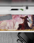 Anime mouse pad 36x16 in. featuring Konosuba's Megumin under sakura trees, her witch hat in a gentle spring breeze.