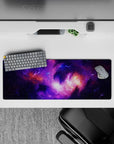 Calming cosmic desk pad 32x12 inches in deep violet, electric lilac, and warm orange nebula glow.