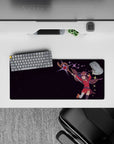 Megumin mid-air with oversized staff, 28x12 inch anime mouse pad from Konosuba, deep plum stars and energy spark.