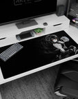 Anime gothic girl with finger-to-lips shh gesture, ruffled dress and ribbons on desk pad, 40x20 inches.