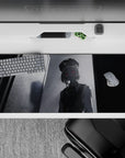 Unsettling 36x16 desk pad featuring a ghostly figure bathed in monochrome tones with an eerie red gaze for a mysterious, cinematic workspace