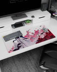 32x16 inches anime girl mouse pad showing a gloved blonde beauty amid pink blossoms and drifting paper.