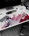 Blonde anime girl in gloves, navy coat and flowing white dress amid pink blossoms on 40x20 inches desk pad.