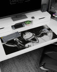 36x16 inches desk pad showing wide-eyed anime girl in curling living-smoke shadows, sweet horror grin.