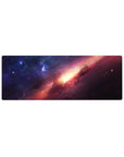 Galaxy nebula desk mouse pad 32x12 inches with star-speckled sky, magenta clouds, and golden glow.