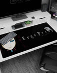 40x20 inches desk pad showing Re-L Mayer staring forward, sharp eyeliner on a gritty alley-wall backdrop.