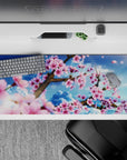 Striking 36x16 desk pad highlights soft pink petals against a vibrant blue sky in stunning artistic detail