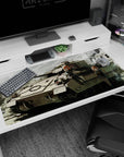 Two orange-haired anime girls pose with rifles on a battle tank desk pad 40x20 inches, city ruins vibe.