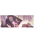 Nezuko lounging under wisteria on a 32x12 inch anime mouse pad from Demon Slayer, surrounded by blush-pink blooms.