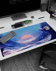 Anime desk pad 40x20 inches showing a cloaked traveler on a jagged snowy cliff above a glowing river at sunset.