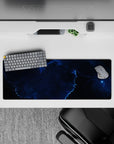 Moody cosmic mouse pad 32x12 inches in deep ocean blues and black with electric blue cloud-edge glow.