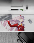 36x16 inches desk pad with Zero Two from Darling in the Franxx, capturing a powerful moment of confidence with her pink hair flowing in the wind.