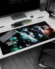 Anime desk pad 40x20 inches showing heroine with glowing sword in black armor beside calm fighter in coat and scarf.
