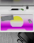 Dynamic 32x16 desk mat combines pink-purple tones, glowing yellow sun, and calm waters for impactful visuals